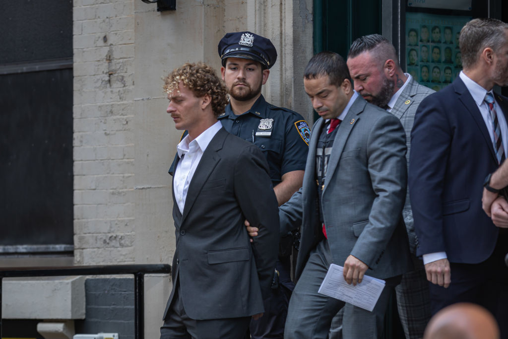 US Marine veteran Daniel Penny, 24, is escorted in handcuffs...