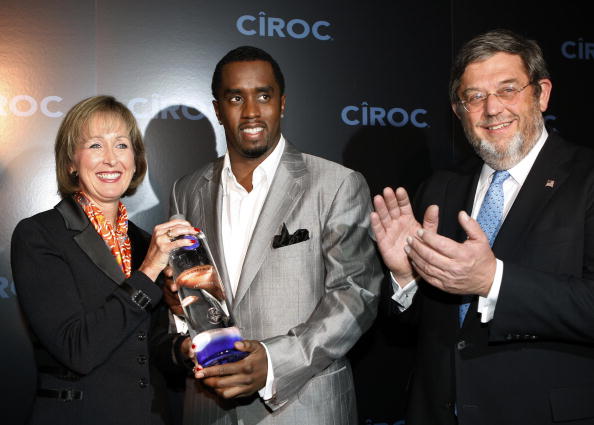 Sean "Diddy" Combs (C) holds a bottle of