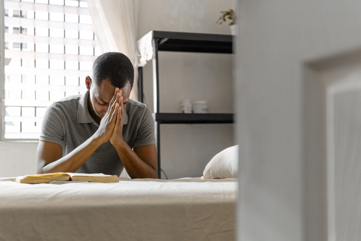 Adult man with hands together making a pray indoor at home. belief concept.