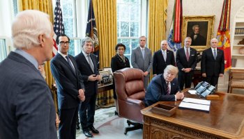 Reportage: President Donald Trump listens as Sen. John Cornyn R-Texas addresses his remarks at the signing of H.R. 266, the Paycheck Protection Program and Health Care Enhancement Act April 24 2020 in the Oval Office