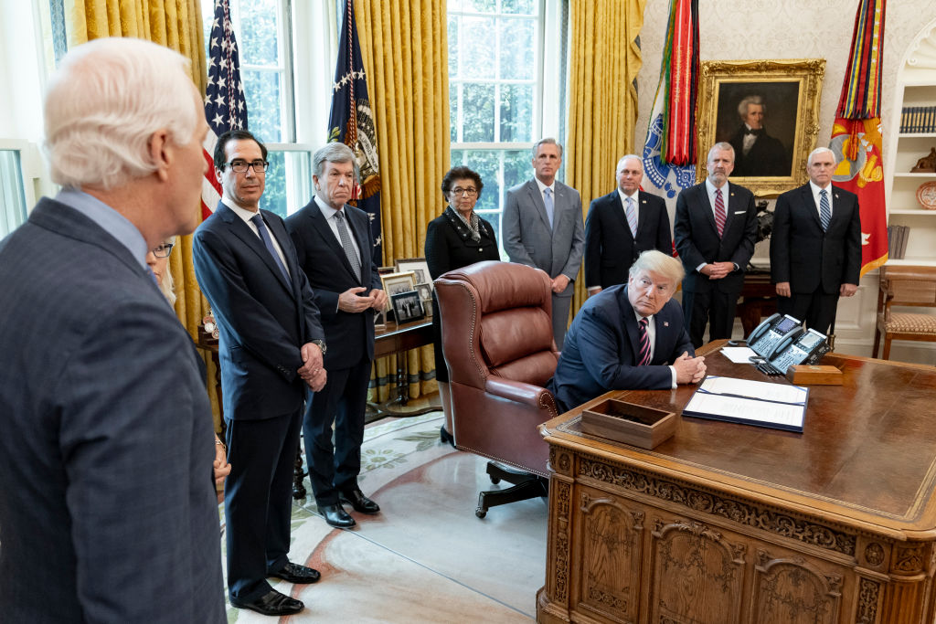 Reportage: President Donald Trump listens as Sen. John Cornyn R-Texas addresses his remarks at the signing of H.R. 266, the Paycheck Protection Program and Health Care Enhancement Act April 24 2020 in the Oval Office