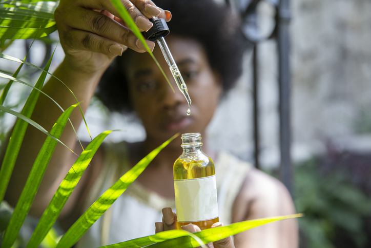 Hand holding a pipette with oil