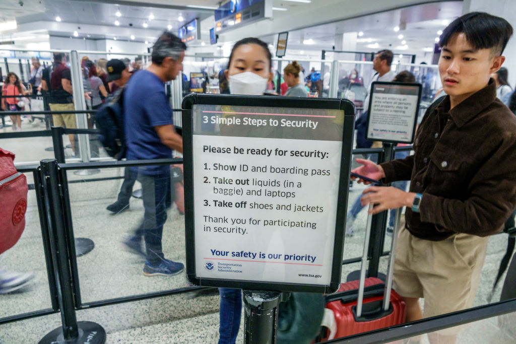 Miami, Florida, Miami International Airport MIA terminal, Transportation Security Administration TSA, Department of Homeland Security, anti-terrorism passenger check-point sign instructions show ID, take-off shoes, show liquids and laptops