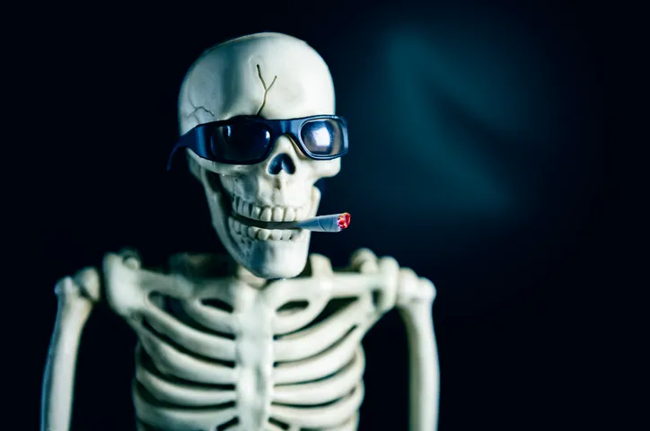Humorous Halloween Skeleton in Sunglasses Smoking Cigarette
