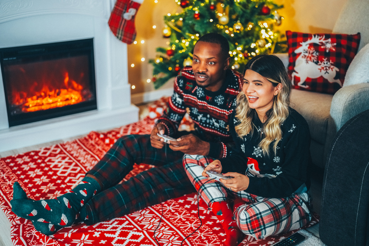 Happy couple on Christmas playing video games