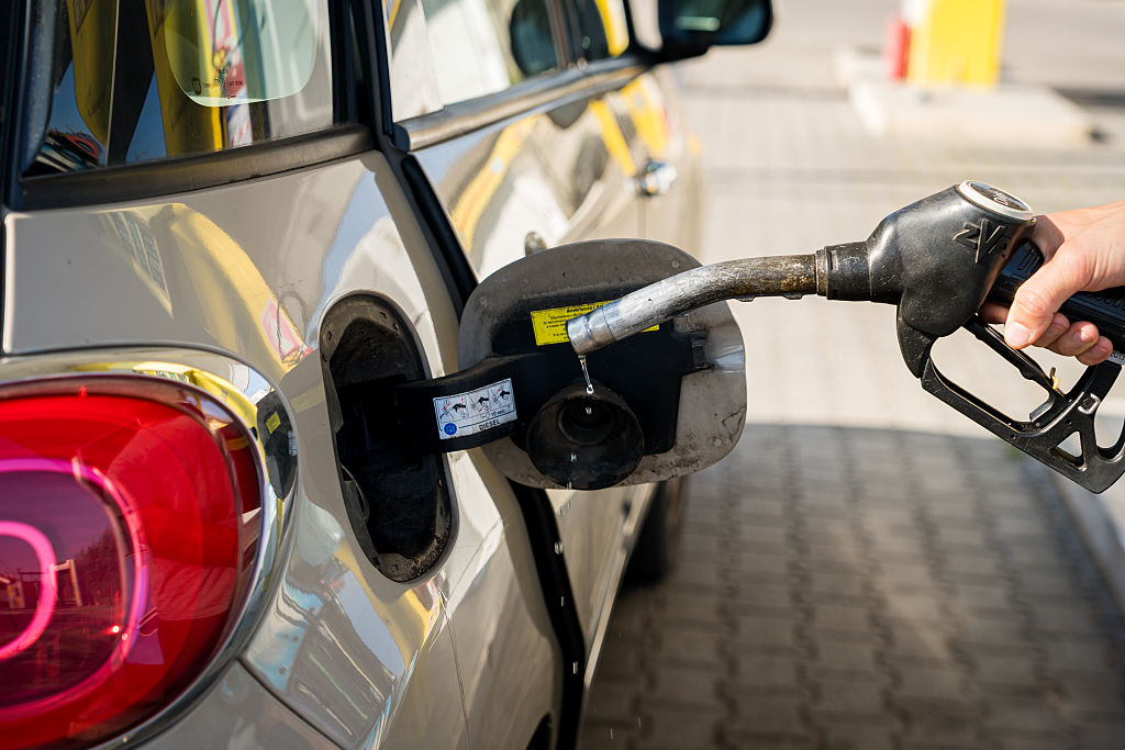 A person is seen refueling a car at a petrol station