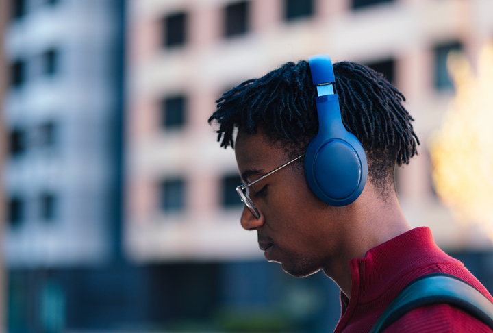 Young adult man listening headphones in urban setting