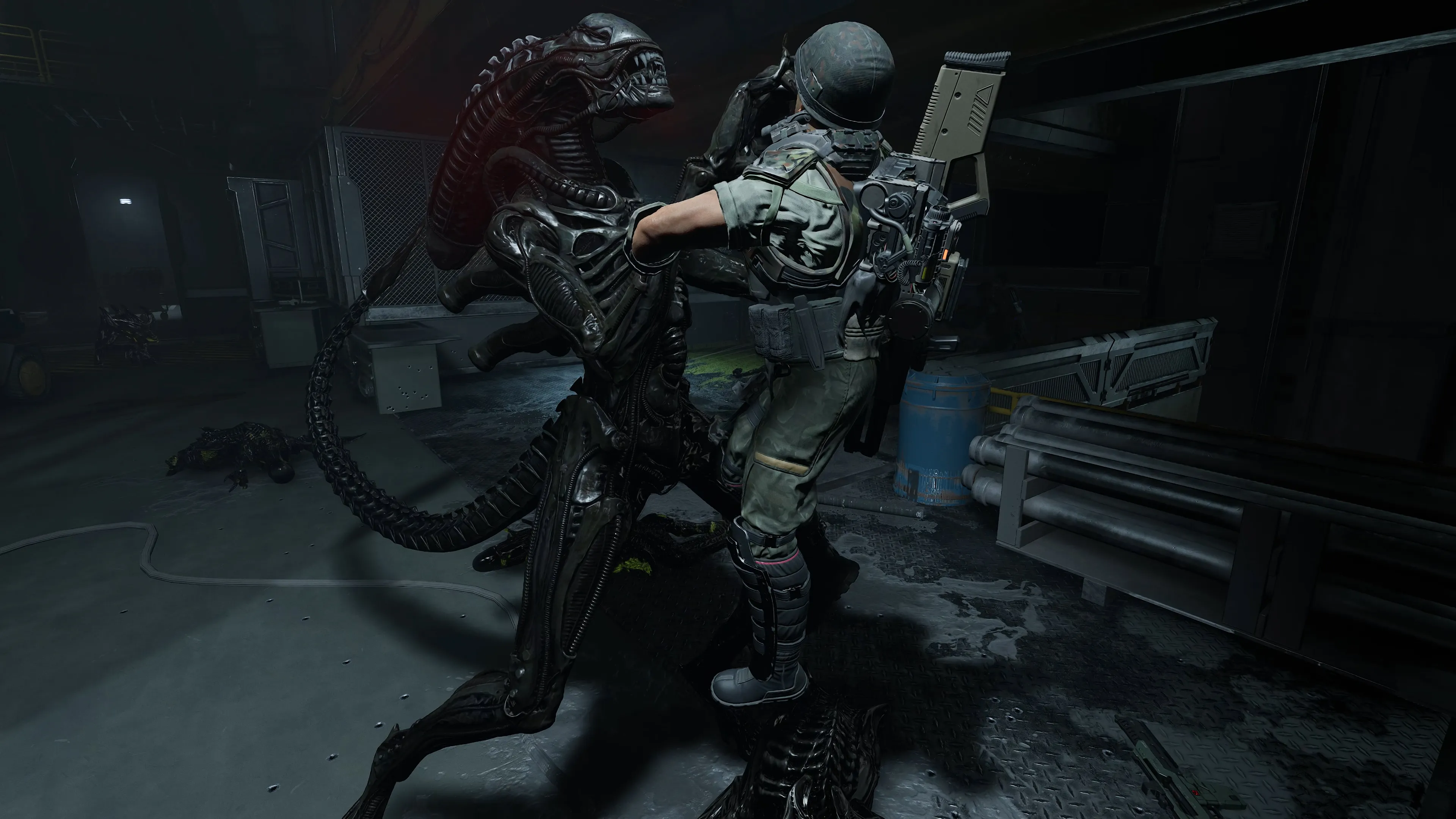 A heavily armed and armored figure, resembling an alien creature, stands in a dark, industrial setting, holding a large weapon.