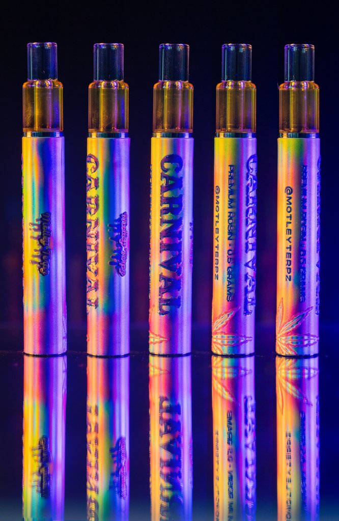 Colorful vape pens with various brand names and designs displayed against a dark background.