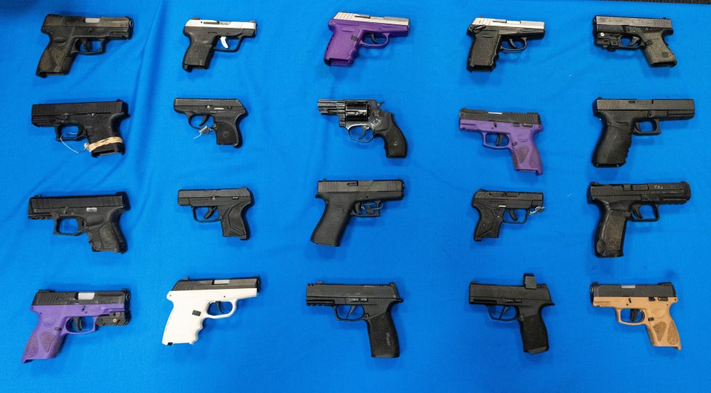 An array of various handguns displayed on a blue background.