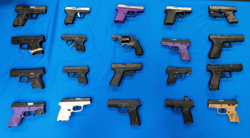 An array of various handguns displayed on a blue background.