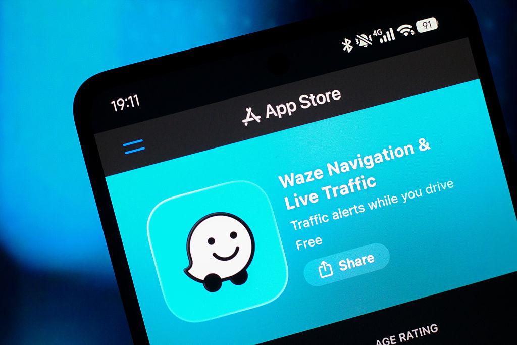 In this photo illustration, the Waze logo is seen displayed