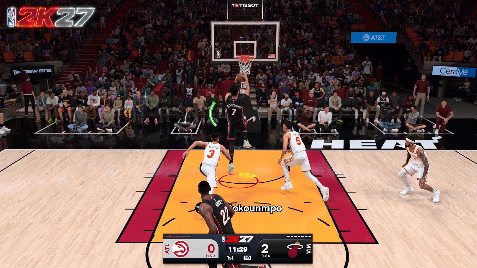 Basketball game in progress with players on the court, scoreboard showing 0-2 in the 1st quarter, and crowd in the stands.