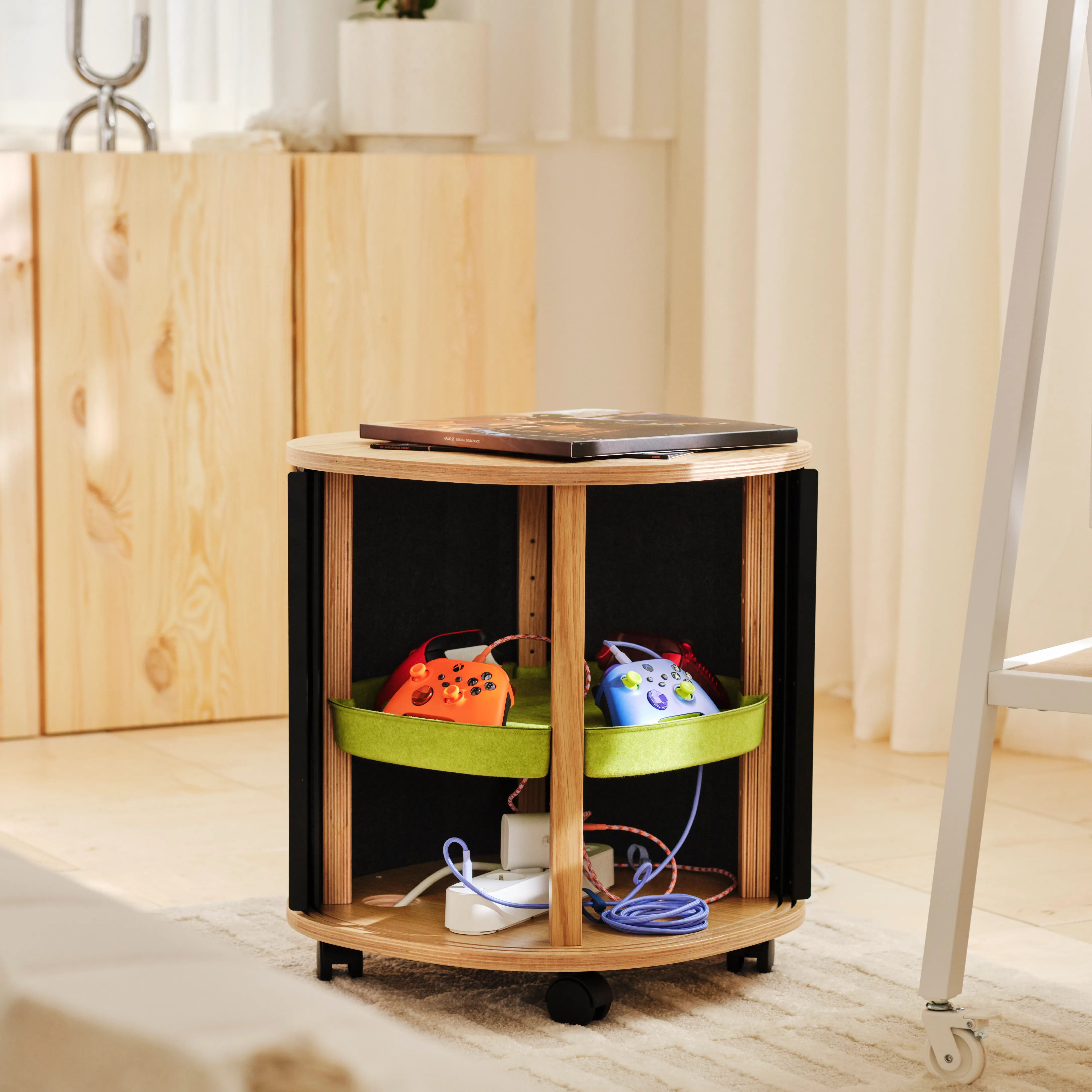 A wooden storage unit with two game controllers and other gaming accessories neatly organized inside.