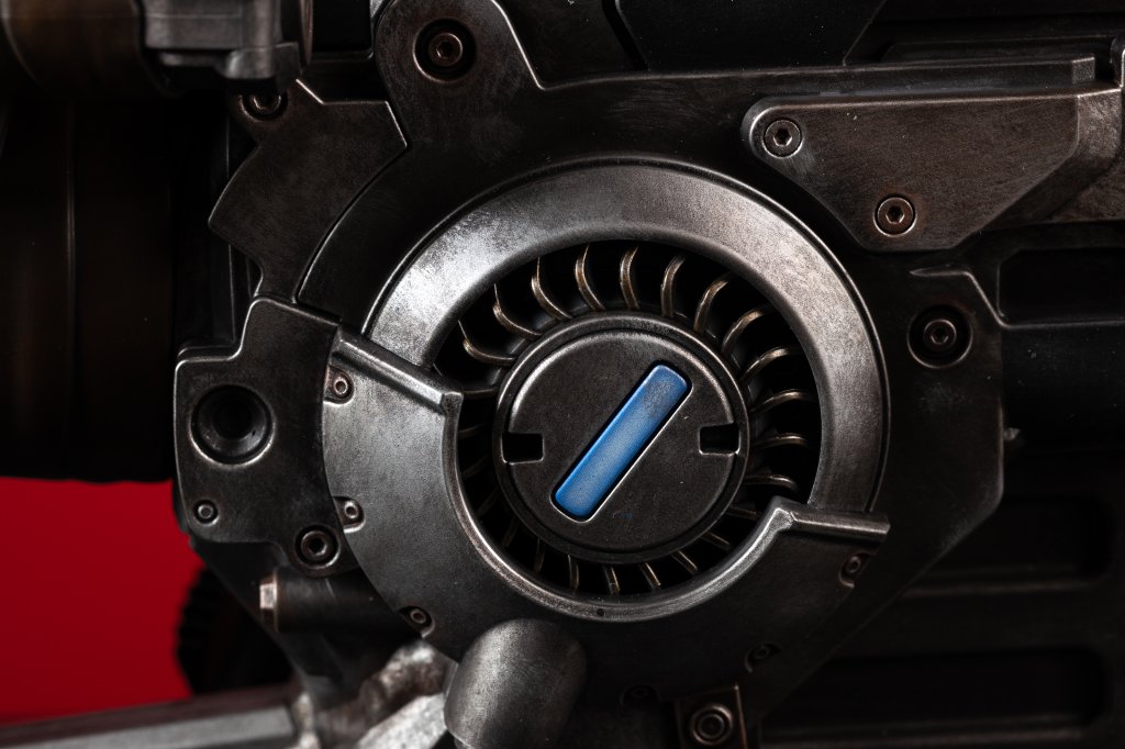 Close-up of a black and silver mechanical device with a blue indicator light.