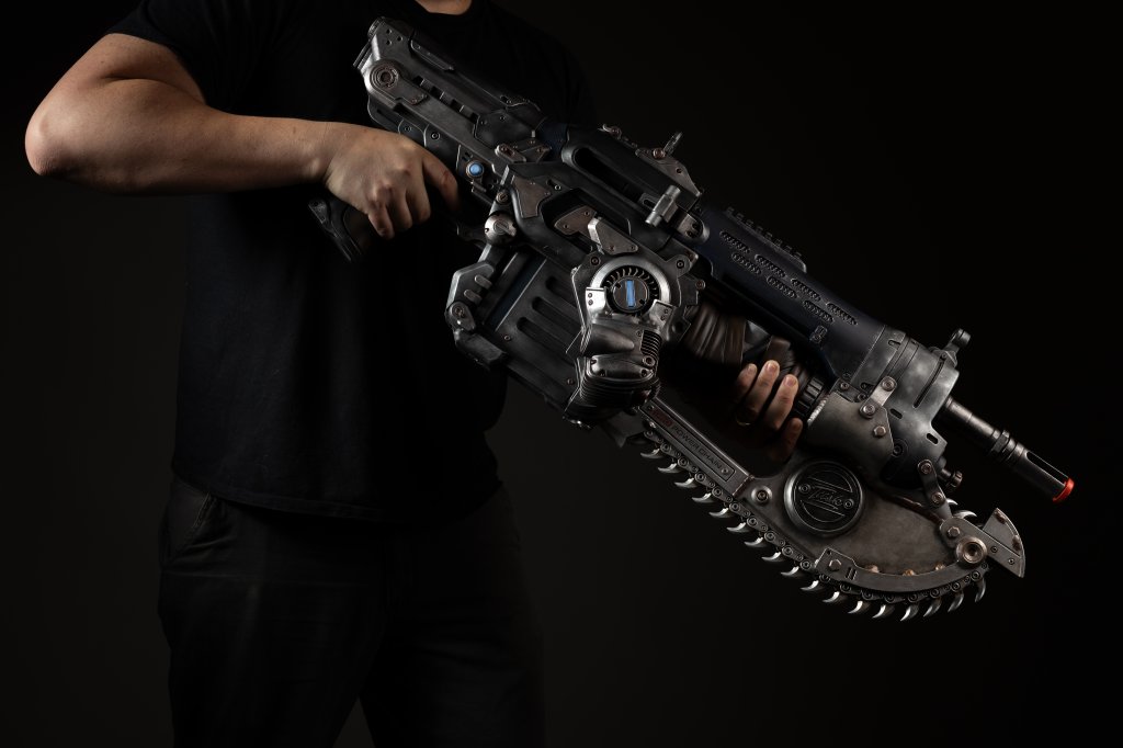 A person holding a futuristic-looking firearm with various mechanical components and attachments.